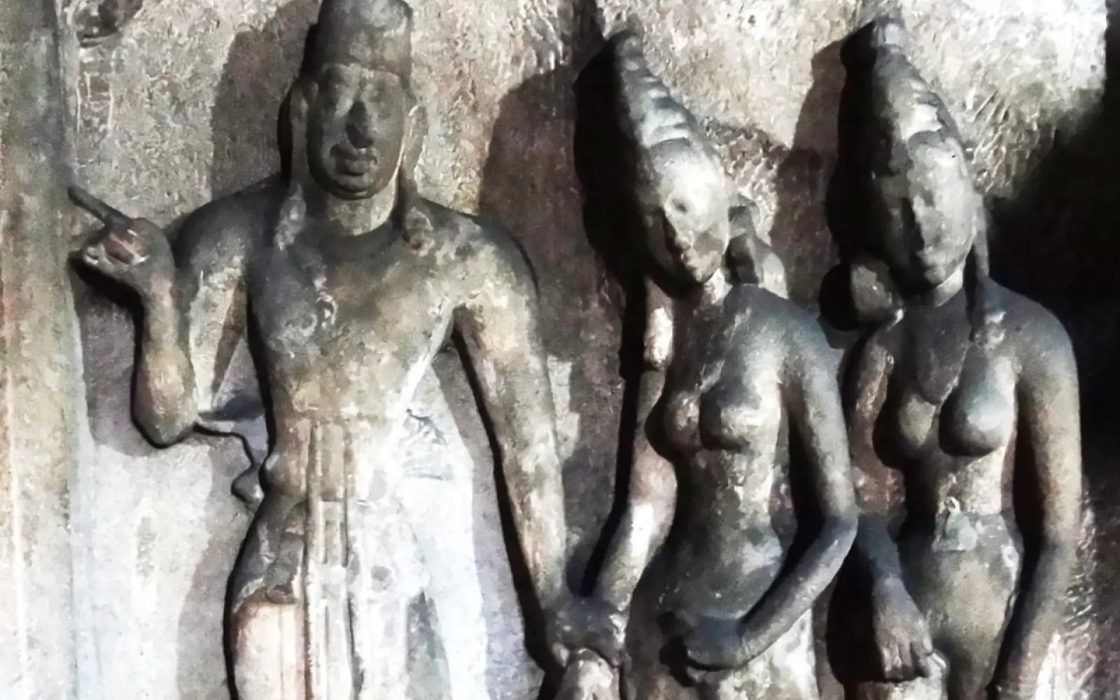 In der Adi Varaha Höhle. Links die Portraitskulptur von Mahendravarman. Seine linke Hand ruht auf dem Handgelenk seiner jungen Königin, die schüchtern an seiner Seite steht. Daneben eine zweite schöne Königin, beide als auffällig sinnliche Frauen dargestellt. Foto: Rainer Schoder