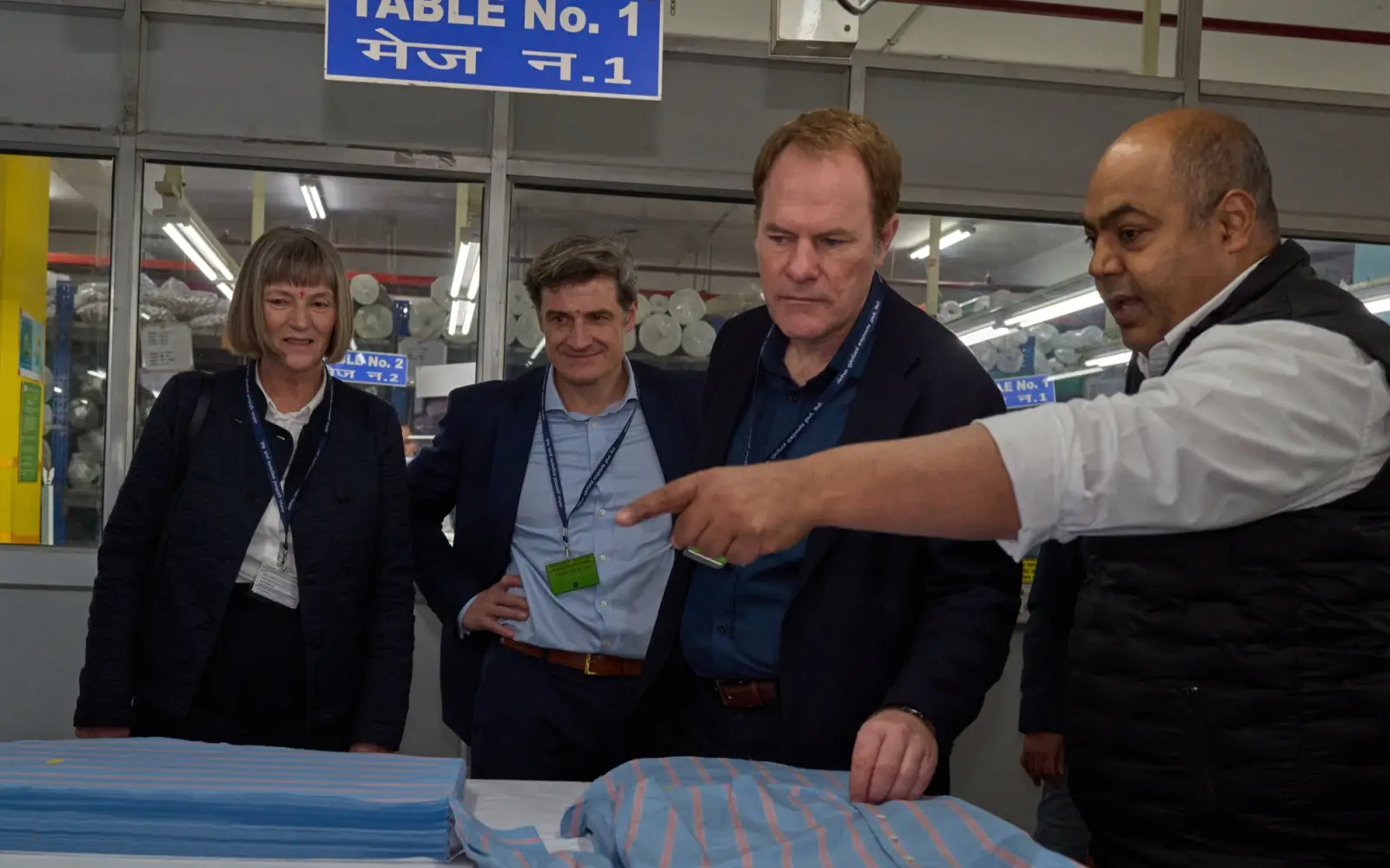 Stadtkämmerin Dorothee Schneider, Wirtschaftsdezernent Christian Zaum und Oberbürgermeister Dr. Stephan Keller (von links) lassen sich von Ravindra Rai die Fertigung eines Oberhemdes zeigen. Foto: Landeshauptstadt Düsseldorf
